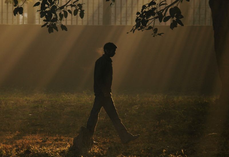Um homem caminha ao longo de uma estrada em uma manhã fria de inverno na cidade indiana de Chandigarh | REUTERS/Ajay Verma