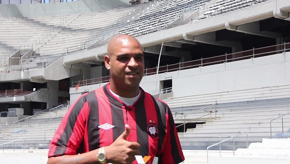Adriano posa na Arena da Baixada: atacante já tem condições de defender o Atlético | Reprodução / TV CAP