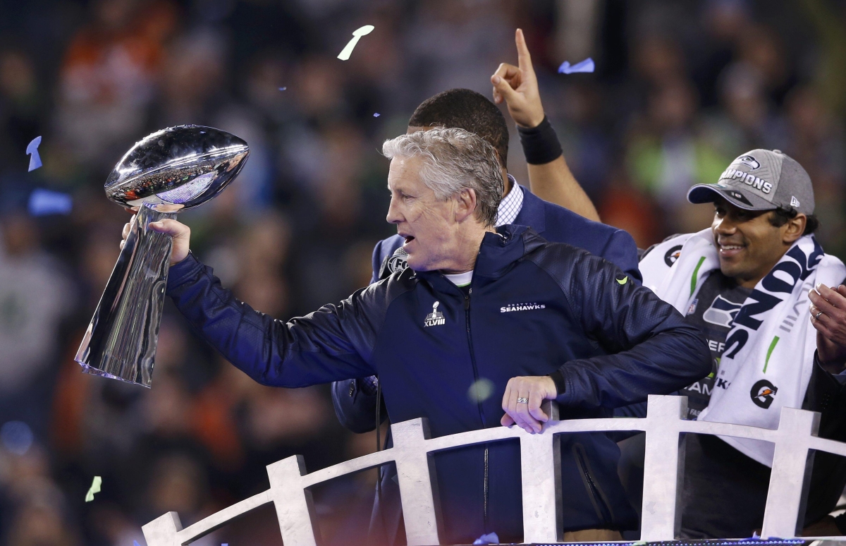 Técnico Pete Carroll, do Seattle Seahawks, levanta o troféu Vince Lombardi após a vitória de seu time na final do Super Bowl 48. À sua direita está o quarterback Russell Wilson | Reuters/Shannon Stapleton