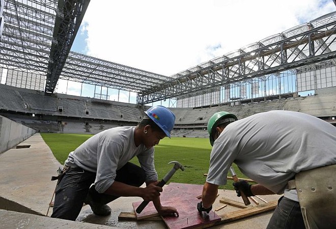 Operários trabalham nas obras da Arena na véspera da decisão da Fifa |