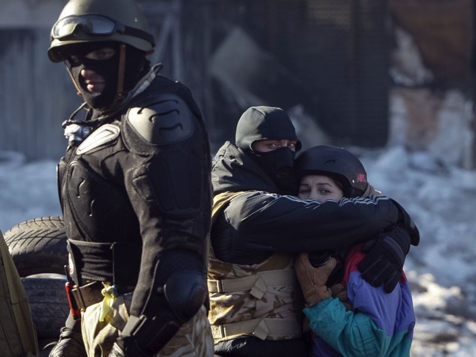 Manifestante abraça sua namorada em uma barricada durante confrontos com a polícia em Kiev, na Ucrânia | REUTERS/Gleb Garanich