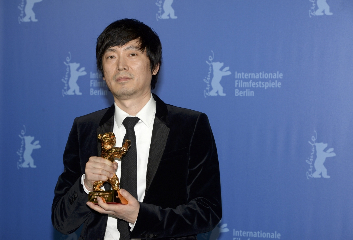 Diao Yinan posa para fotos com o Urso de Ouro do Festival Internacional de Cinema de Berlim | Reuters/Patrik Stollarz/Compartilhamento