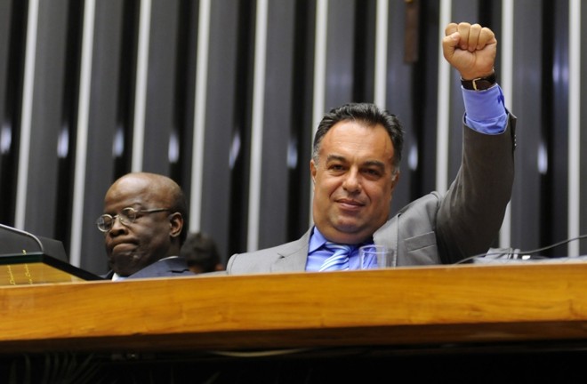 Ao lado do presidente do STF, Joaquim Barbosa, o deputado federal André Vargas (PT) faz gesto adotado pelos políticos presos no processo do mensalão |