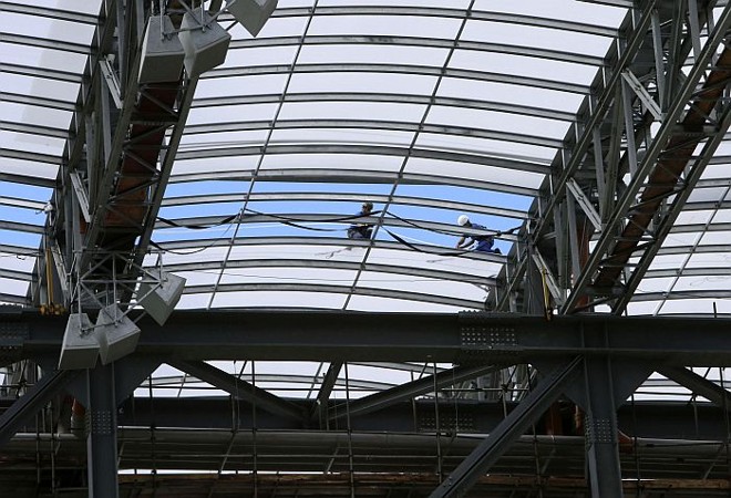 Operários trabalham na cobertura das obras da Arena na véspera da decisão da Fifa |
