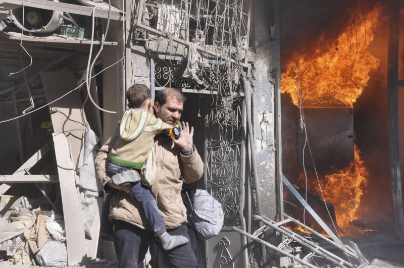 Homem resgata criança em local próximo a onde ocorreram explosões em Aleppo, na Síria | REUTERS/Yaman Al Halabi