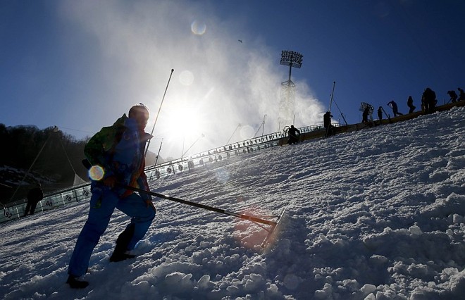 A organização dos jogos prepara a pista do esqui cross-country |