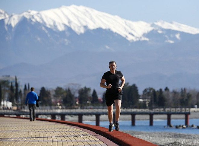 Russo corre no Parque Olímpico de Sochi com as montanhas ao fundo: falta de neve preocupa | 