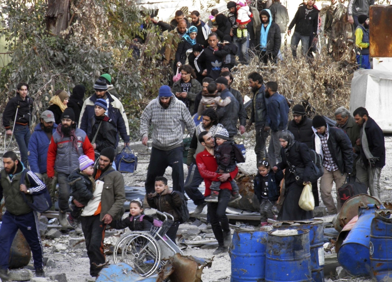 Civis caminham até um ponto de encontro de onde seriam tirados de Homs sitiada | Thaer Al Khalidiya/Reuters