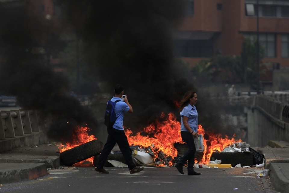 Manifestantes contra o presidente Nicolás Maduro começaram a montar barricadas em Caracas, incendiando algumas delas, apesar de a oposição pedir protestos pacíficos | Tomas Bravo/Reuters