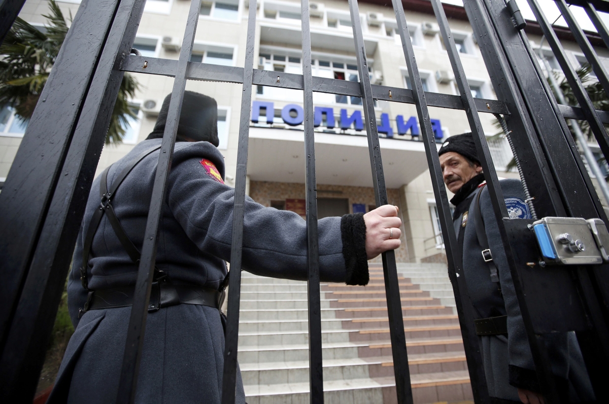 Policiais guardam a entrada da delegacia em Sochi onde estão presas Nadezhda Tolokonnikova e Maria Aliojina | Reuters/Eric Gaillard