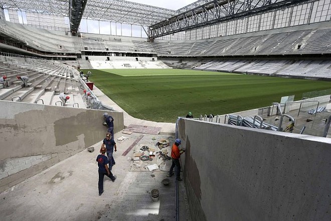 Operários trabalham nas obras da Arena na véspera da decisão da Fifa |