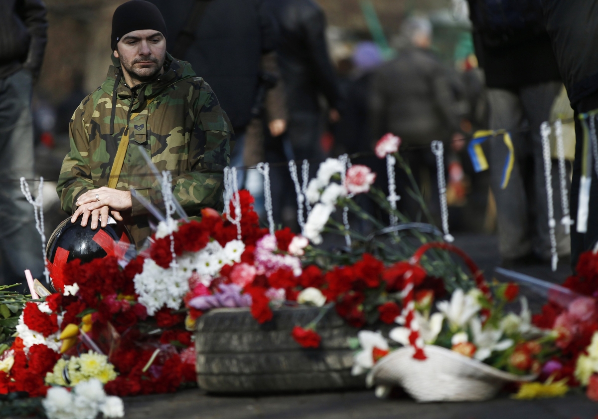 Homem presta homenagem aos mortos durante protestos contra o presidente deposto da Ucrânia | Reuters/David Mdzinarishvili