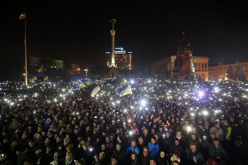 Manifestantes acendem tochas e dispositivos de celulares durante comício na Praça da Independência, em Kiev | REUTERS / Baz Ratner