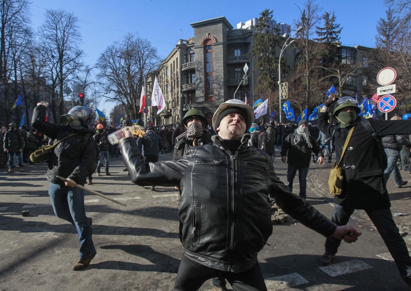 Homem arremessa coquetel molotov contra a polícia, cercado por outros armados de pedras | Gleb Garanich/Reuters