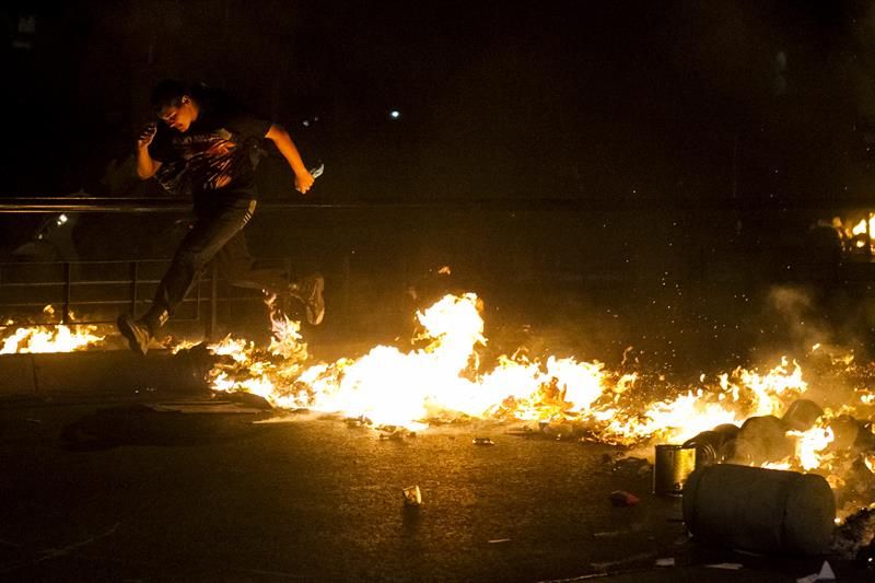 Manifestantes colocaram fogo em pneus, quebraram vidros de lojas e painéis e picharam placas e prédios públicos | Miguel Gutiérrez / EFE