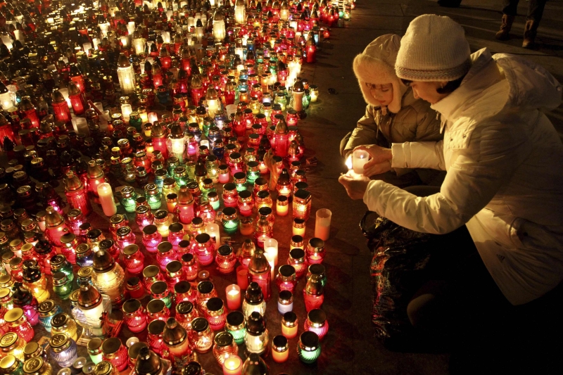 Mulher acende vela no centro de Kiev, em homenagem aos mais de 70 mortos registrados durante os confrontos no país | Marian Striltsiv/Reuters