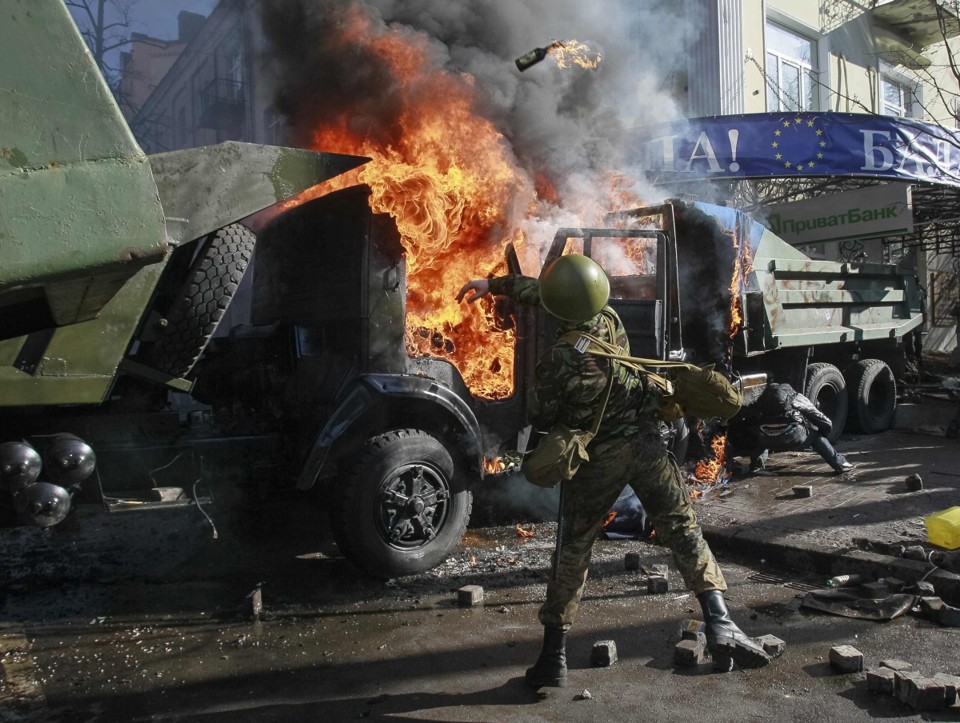 Manifestante atira coquetel molotov contra a sede do partido do governo em Kiev, capital da Ucrânia | Reuters/Gleb Garanich