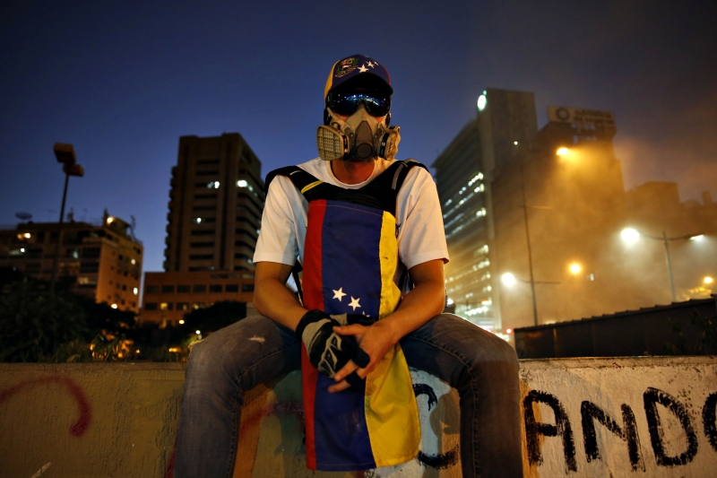 Manifestante sentado em muro da Praça Altamira, em Caracas: internet é usada para mobilizar os opositores ao governo | Carlos Garcia Rawlins/Reuters