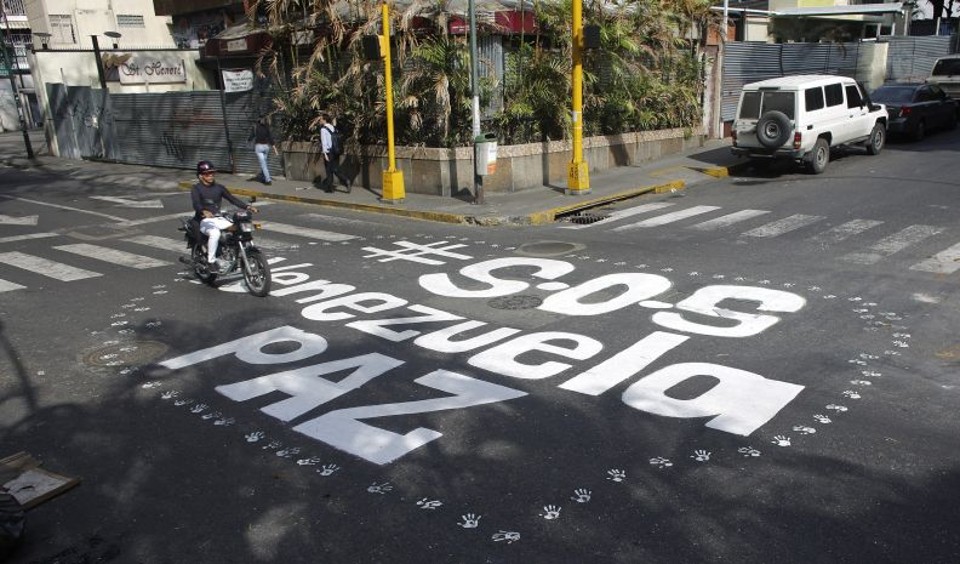 Pintura no asfalto pede paz na Venezuela | REUTERS/Tomas Bravo