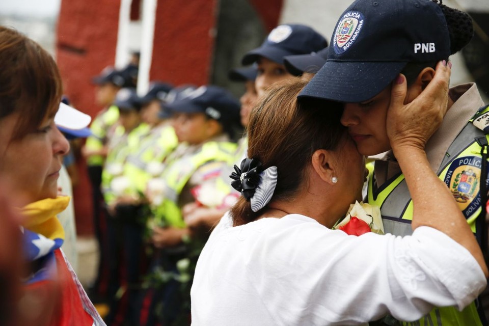 Nesta quarta-feira, na capital Caracas, mulheres partidárias da oposição saíram às ruas e cumprimentavam agentes do governo | REUTERS/Carlos Garcia Rawlins