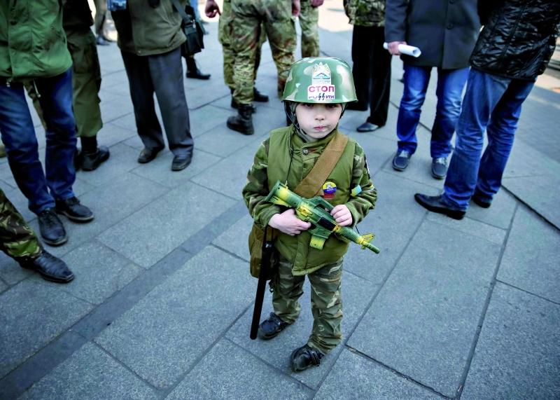 Menino usa uniforme militar em protesto contra guerra na Praça da Independência, em Kiev | Gleb Garanich/Reuters