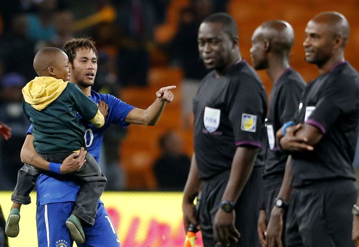 Neymar com o menino Ayo Dosumo, que entrou no campo no amistoso do Brasil com a África do Sul | Siphiwe Sibeko / Reuters