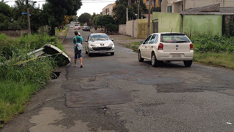 Perigo é maior para pedestres, que precisam dividir o restante da rua com os carros. Guarda-corpo está suspenso sobre buraco. | Ellen Miecoanski/Gazeta do Povo