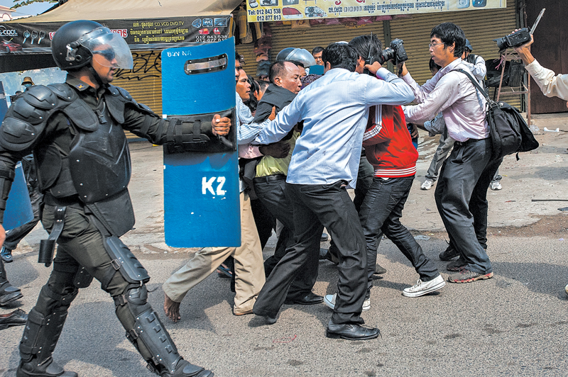 Apoiadores protegeram Mam Sonando da tropa de choque durante um protesto em janeiro | Fotos: Luc Forsyth para The New York Times