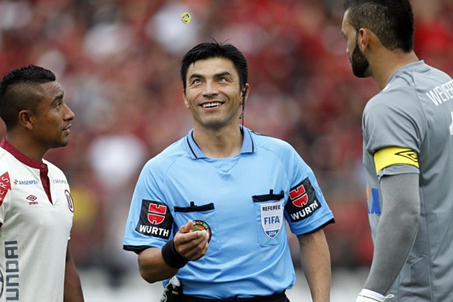 O árbitro chileno Patricio Polic durante o sorteio dos lados de campo com os capitães |