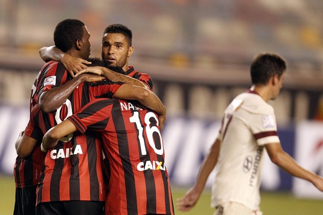 Éderson quase some diante dos abraços dos companheiros após ter feito o gol da vitória atleticana em Lima | 