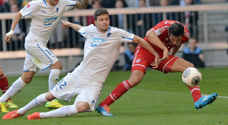 Claudio Pizarro (à direita), do Bayern, e Tobias Strobland, do Hoffenheim, disputam a bola em partida do Campeonato Alemão | EFE/EPA/PETER KNEFFEL