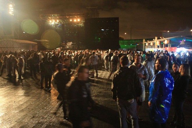 Pessoas aguardam início da apresentação perto do palco |