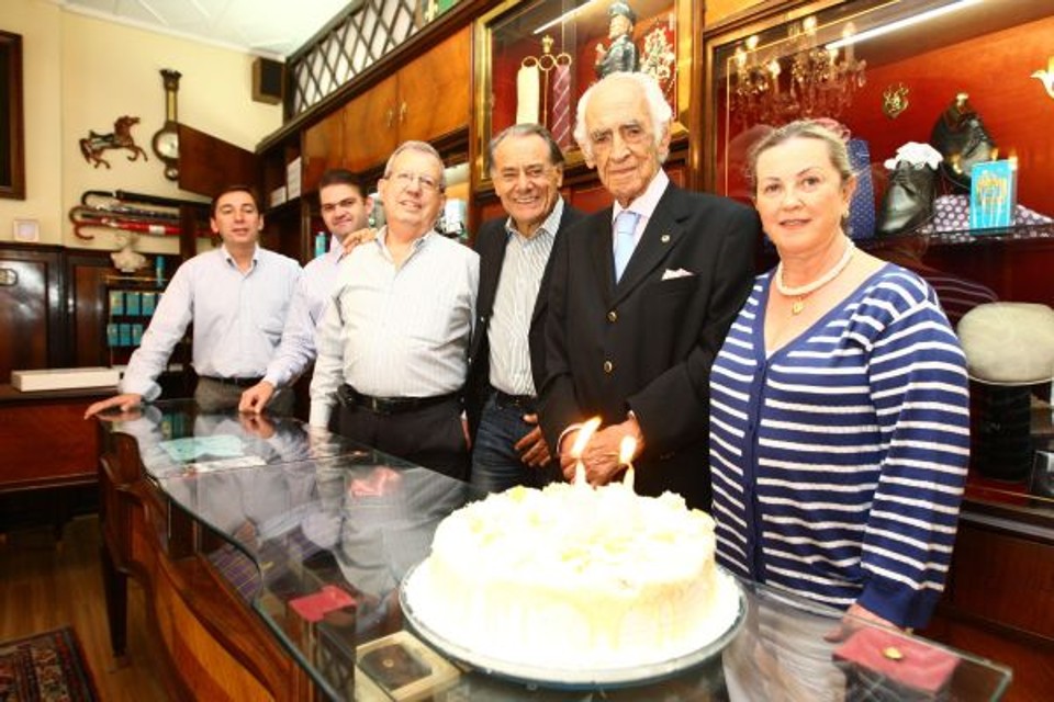 Carlos da Costa Coelho, dono da tradicional loja de roupas masculinas ao lado da Praça Osório, foi surpreendido ontem por amigos que levaram um bolo para celebrar seu aniversário. À frente da Loja Coelho desde 1957, Seu Coelho comemora 90 anos junto com o Atlético, seu time de coração. Na foto, da esquerda para a direita, Wanderley Ribeiro, Everton Gomes, Fortunato Guedes e José Eduardo Alves Ferreira com Carlos da Costa Coelho e a mulher dele, Claudette | Ivonaldo Alexandre/Gazeta do Povo
