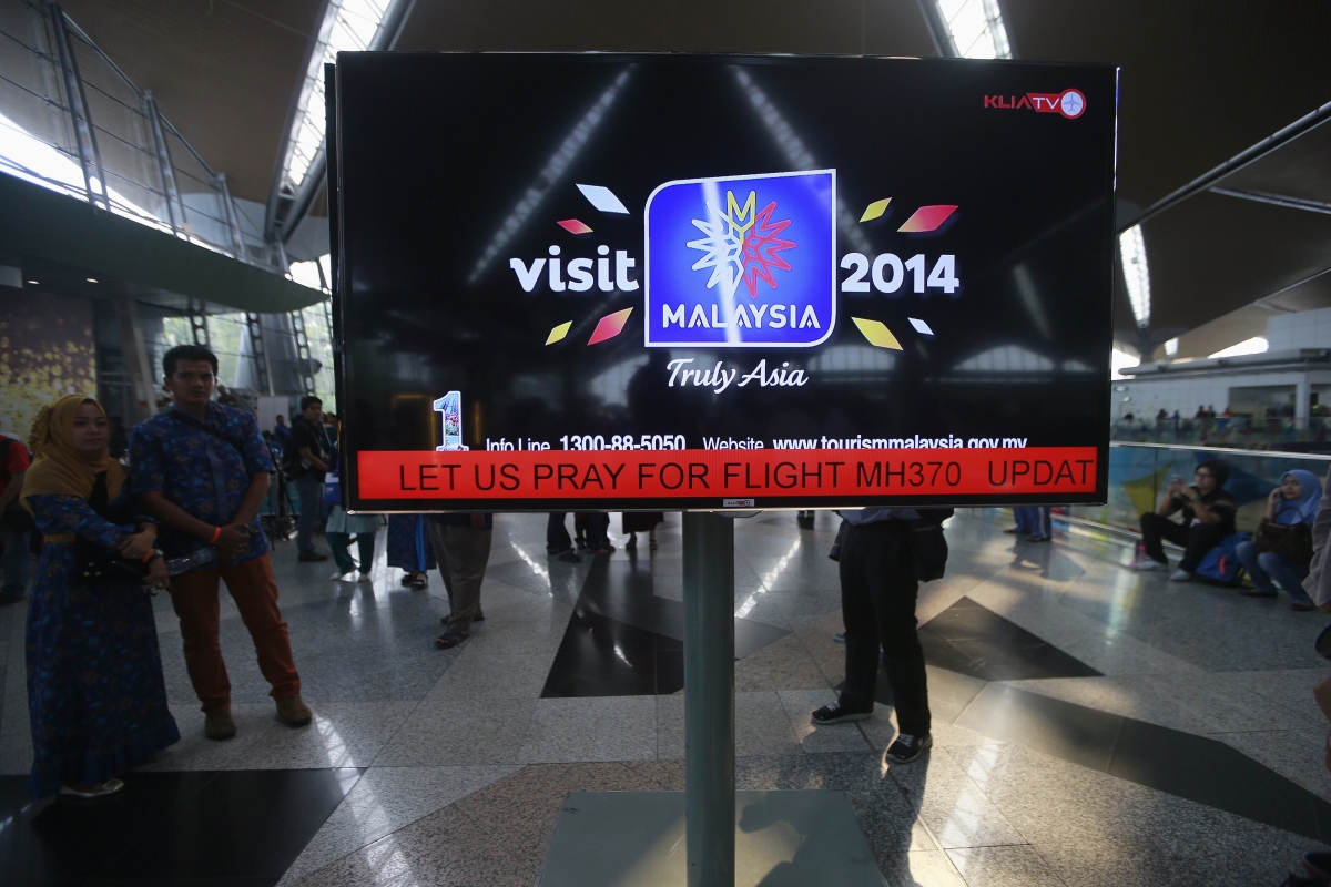 Cartaz no aeroporto internacional de Kuala Lampur pede orações pelos ocupantes do voo MH370 | Reuters/Samsul Said