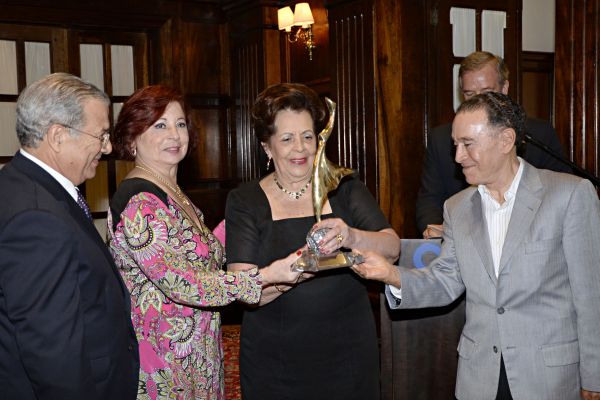 Observada pelo presidente em exercício da Associação Comercial do Paraná, José Eduardo Sarmento, dona Leda Leão recebe o troféu Mulher Simplesmente Mulher 2014 da coordenadora do Conselho da Mulher Executiva da ACP, Edda de Melo e Silva (vestido estampado), e do presidente do Graciosa Country Club, João Carlos Ribeiro. A homenagem ocorreu durante o tradicional Chá da Tarde do Graciosa Country Club, na quarta-feira | Suellen Lima