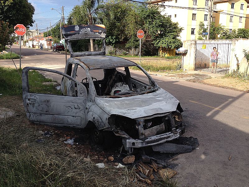 Carro incendiado à 1 hora da madrugada permaneceu durante toda esta segunda-feira recebendo a visita de curiosos, alguns inclusive abriram portas e retiraram partes do que sobrou do veículo. | Ellen Miecoanski/Gazeta do Povo
