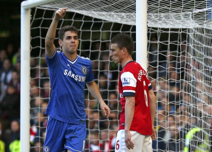 O meia brasileiro Oscar comemora seu gol diante do zagueiro Laurent Koscielny, do Arsenal. | Reuters/Eddie Keogh