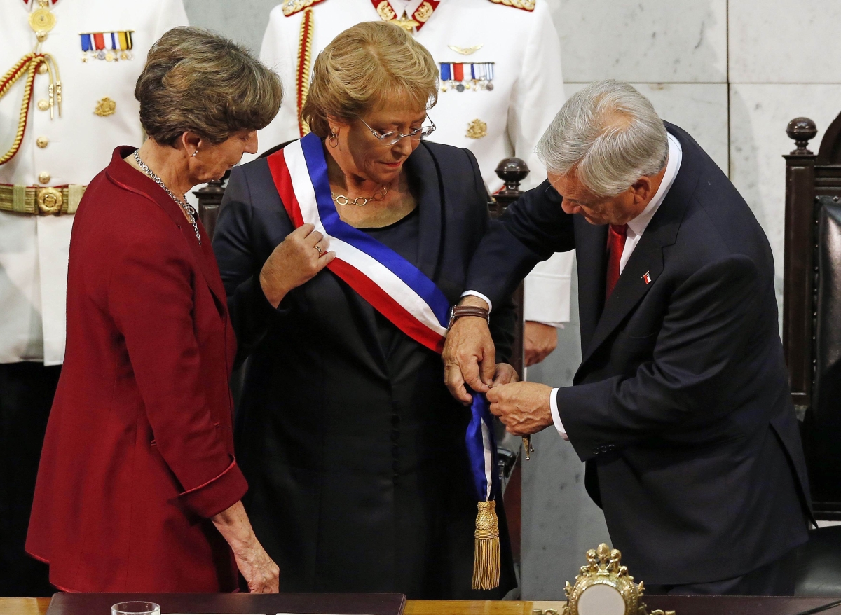 Michelle Bachelet (ao centro) recebe a faixa presidencial de Sebastián Piñera (à dir.). A presidente do Senado do país, Isabel Allende (à esq.), também participou do ato | Reuters/Ivan Alvarado