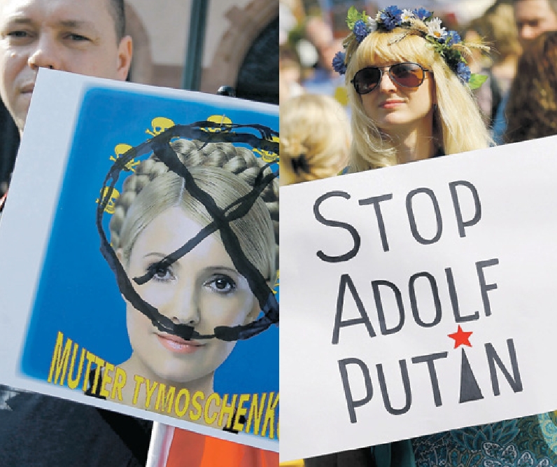 Na Ucrânia, ativistas exibem cartazes criticando a ex-premiê Yulia Tymoschenko e o presidente russo Vladimir Putin | Kai Pfaffenbach/Reuters