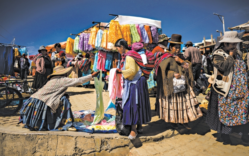Mansões coloridas e proliferação de padarias, sinais de que muitos bolivianos têm dinheiro extra para gastar; mercado em El Alto, cidade operária | meridith kohut para The New York Times