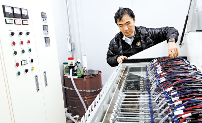 Satoshi Matsuoka em um protótipo de supercom-putador em Tóquio que é resfriado por submersão em um tanque de óleo mineral | jeremie souteyrat para The New York Times