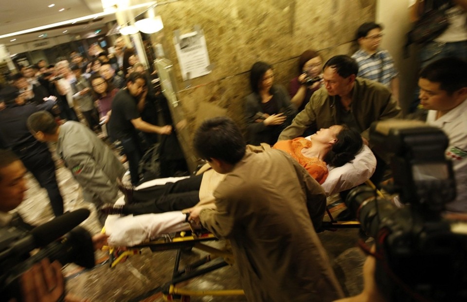 Familiar de um dos passageiros do voo MH370 passa mal e é levada de maca para um ambulância, em Pequim | Kim Kyung-Hoon/Reuters