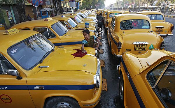 Sumitra Sarkar, 35, limpa dez carros diariamente por 150 rúpias indianas. Na foto, ela limpa um táxi amarelo em Kolkata, Índia | REUTERS/Rupak De Chowdhuri