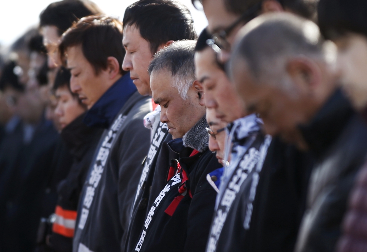 Policiais e bombeiros da região de Fukushima fazem um minuto de silêncio pelos mortos no terremoto e posterior tsunami de 2011, no Japão | Reuters/Toru Hanai