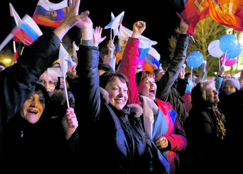Milhares de pessoas celebraram ontem a vitória da reunificação no referendo em uma praça na capital crimeana | Baz Ratner/Reuters