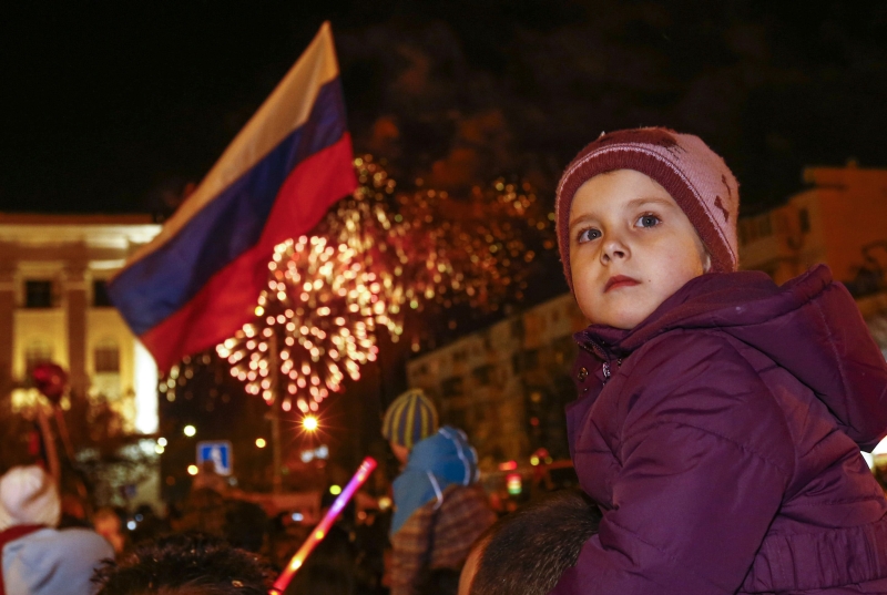 Criança acompanha celebração em Simferopol, na Crimeia, região que se separou da Ucrânia | Shamil Zhumatov/Reuters