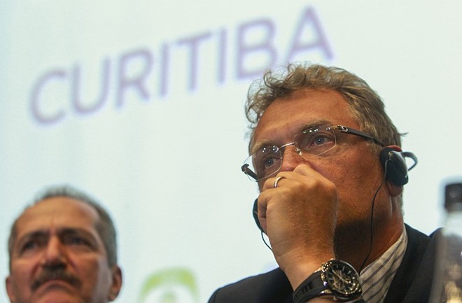 19/8/2013 - Em oito meses, o cenário já é bem menos claro. Preocupado com o cumprimento do cronograma, Valcke recomenda que o Atlético tire o teto retrátil do projeto para a Copa. Petraglia garante -- na reunião com o secretário-geral e em coletiva -- que qualquer acréscimo de orçamento seria bancado pelo clube, ideia que ele mesmo abandonaria pouco depois, exigindo a manutenção do acordo tripartite.