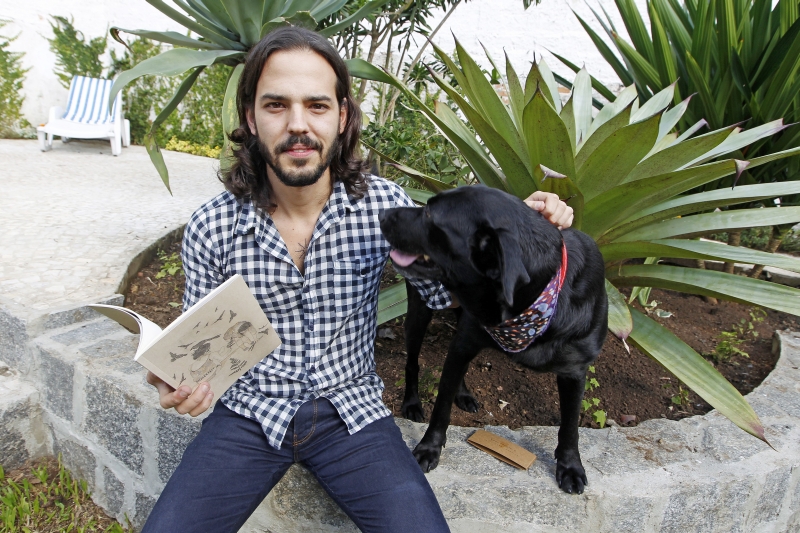 O artista com a nova moradora, Preta, que não largou o dono durante a sessão de fotos | Antônio More/Gazeta do Povo