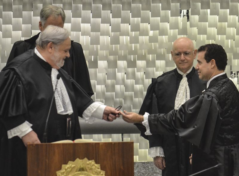 O presidente do STJ, Félix Fischer, repassa caneta para Néfi Cordeiro assinar a posse como ministro do STJ. Os dois têm origens no Paraná | José Cruz / Agência Brasil
