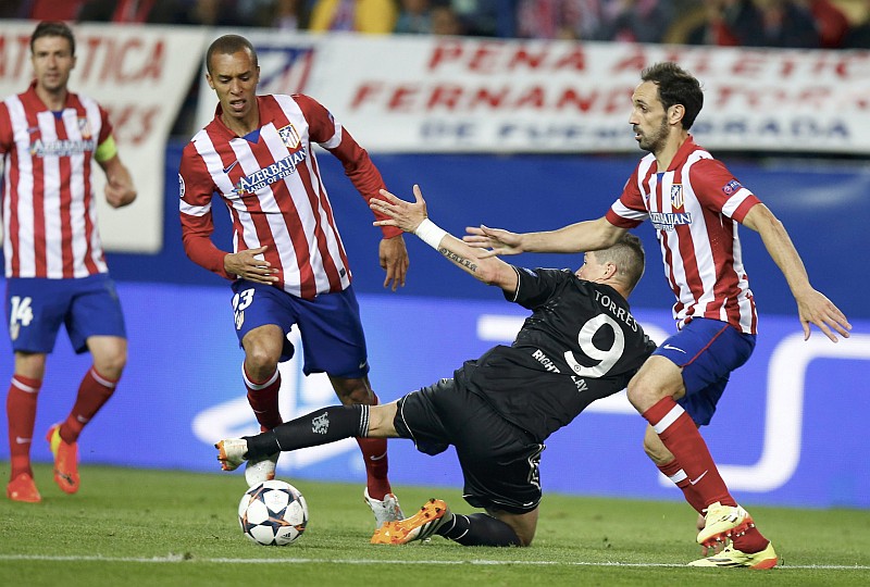 O zagueiro paranaense Miranda do Atlético de Madrid derruba Fernando Torres do Chelsea: jogo foi truncado na Espanha | Sergio Pérez / Reuters